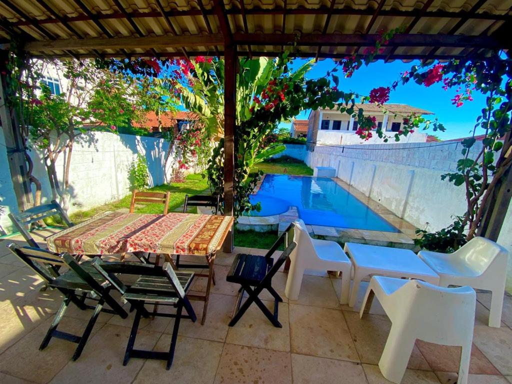 eine Terrasse mit Tisch und Stühlen und einem Pool in der Unterkunft Casa 3 Quartos, 50 metros Da Praia in Cascavel