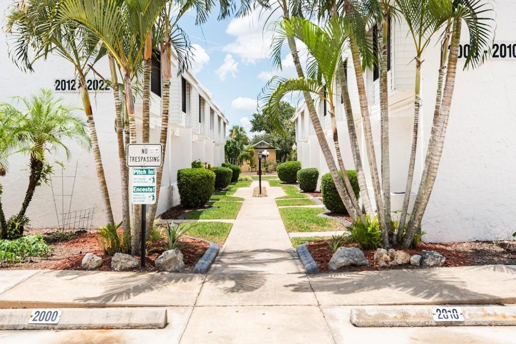 einen Gehweg vor einem Gebäude mit Palmen in der Unterkunft Historic Sebring Downtown Home in Sebring
