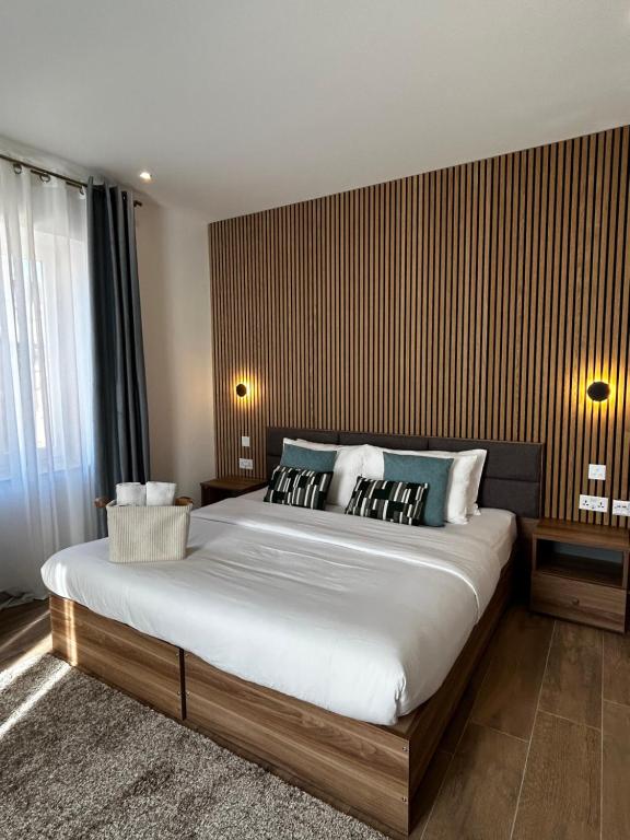 a bedroom with a large bed with a wooden wall at Tritoni Casa Kappuccini in Il-Furjana