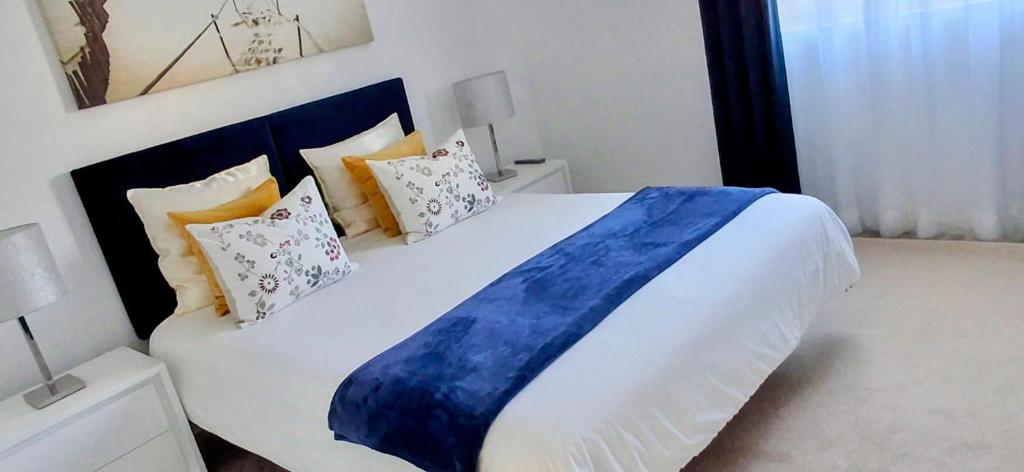 een slaapkamer met een groot bed met kussens bij Ribeiro´s House in Gafanha da Nazaré