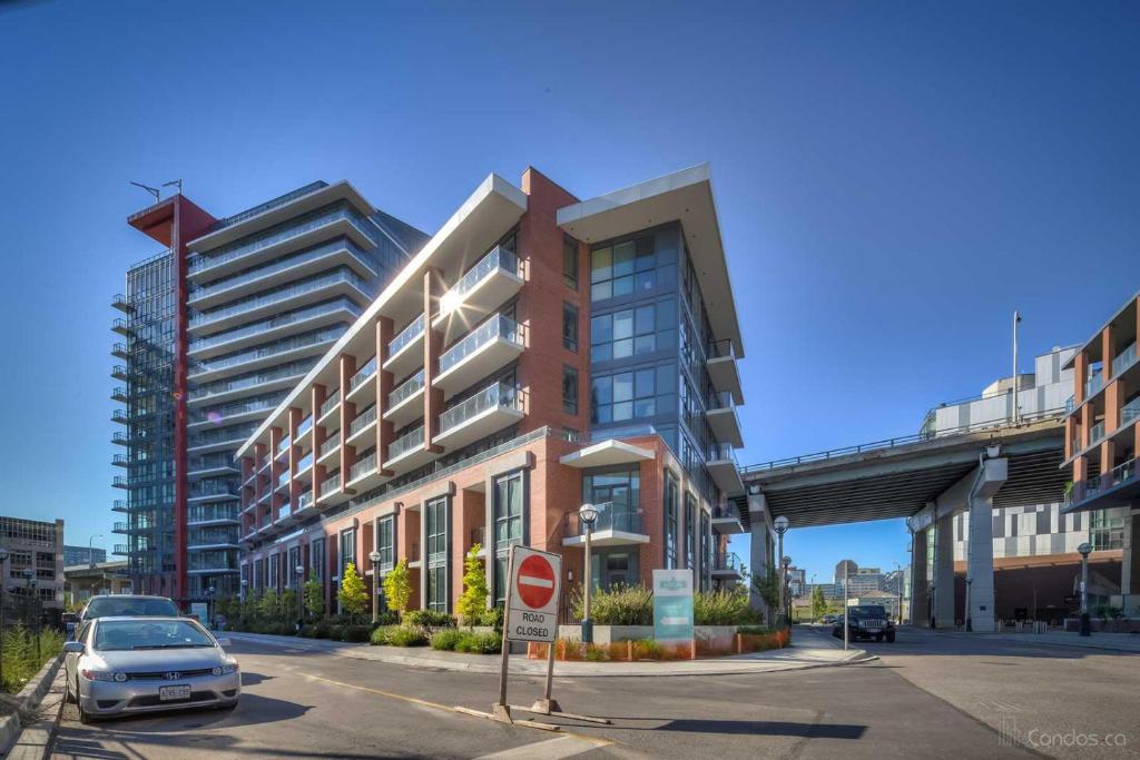 ein Auto, das vor einem Gebäude in einer Straße geparkt ist in der Unterkunft Luxury CN Tower Suites - Save on Monthly Stays in Toronto