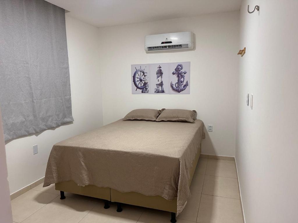 a bedroom with a bed in a white room at Suite 05 em casa Beira mar, com ar condicionado , cozinha completa com Micro ondas air fryer forno elétrico fogão Geladeira freezer gelagua e cafeteira elétrica Tudo para vc se sentir em casa além de um Deck com churrasqueira vista mar in Icapuí