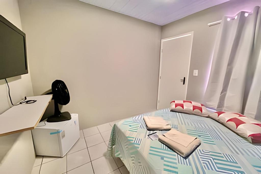 a bedroom with a bed and a flat screen tv at Sol Calor e Mar, achei minha pousada in Matinhos