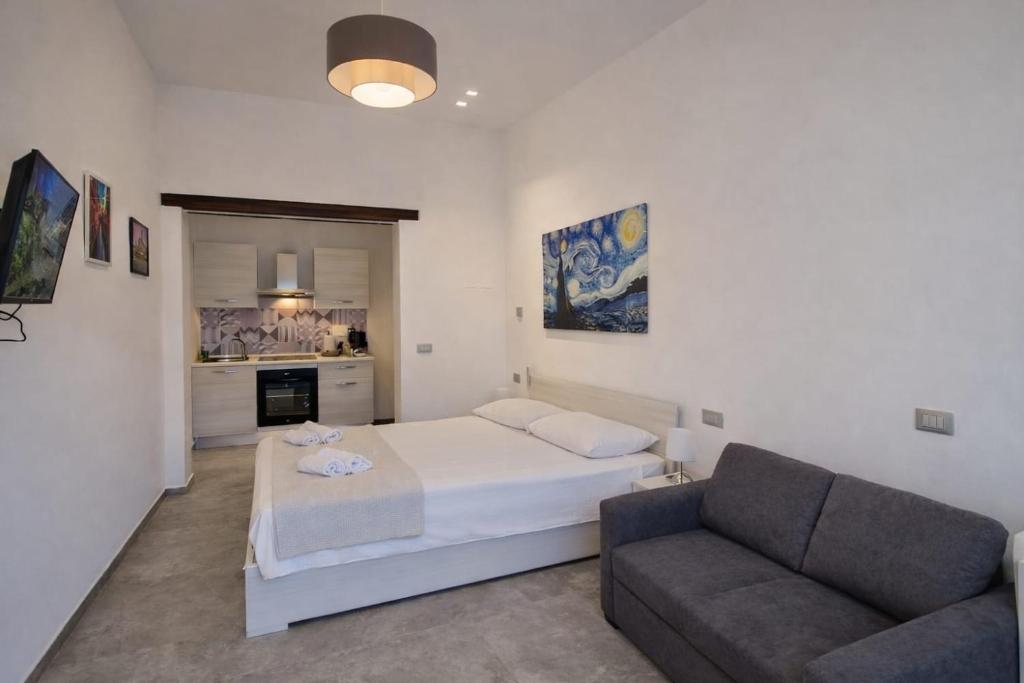 een slaapkamer met een bed en een bank bij GemmaHouse in Casalecchio di Reno