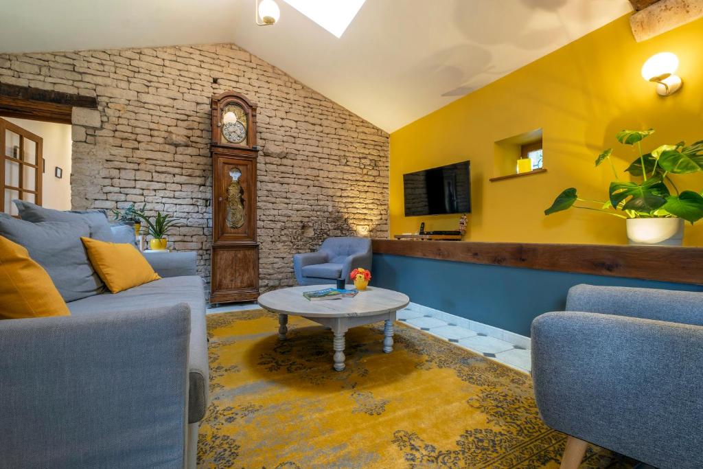 ein Wohnzimmer mit Sofa und Tisch in der Unterkunft Gîtes de la Bernière in Brûlain