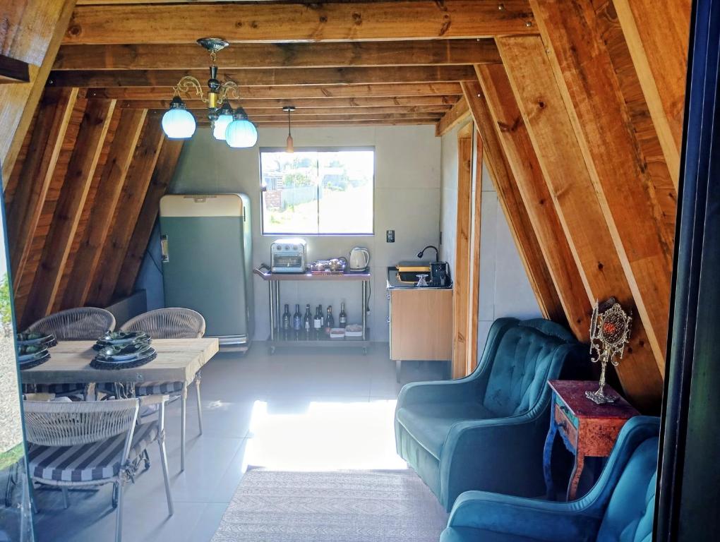een woonkamer met een blauwe bank en een tafel bij Chalé Venanzi in São Francisco do Sul