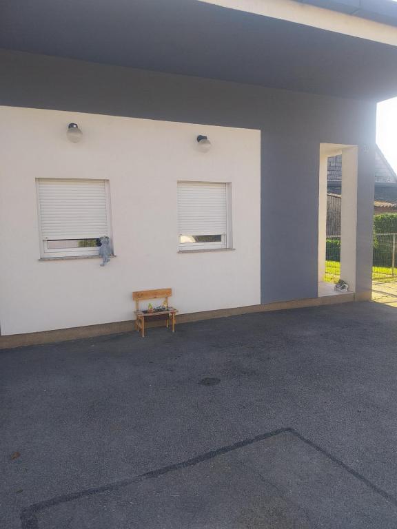 una stanza vuota con due finestre e una panca di apartmani mikek a Domaslovec