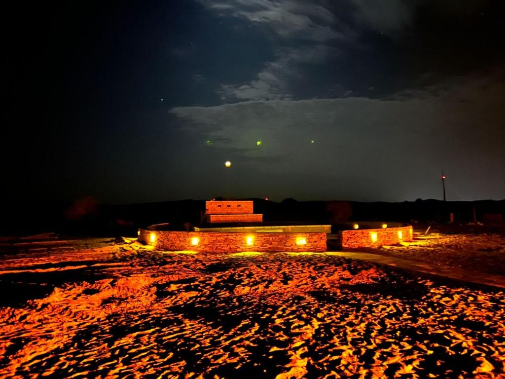 a building with lights in a desert at night at magic heritage camp& resort in Jaisalmer