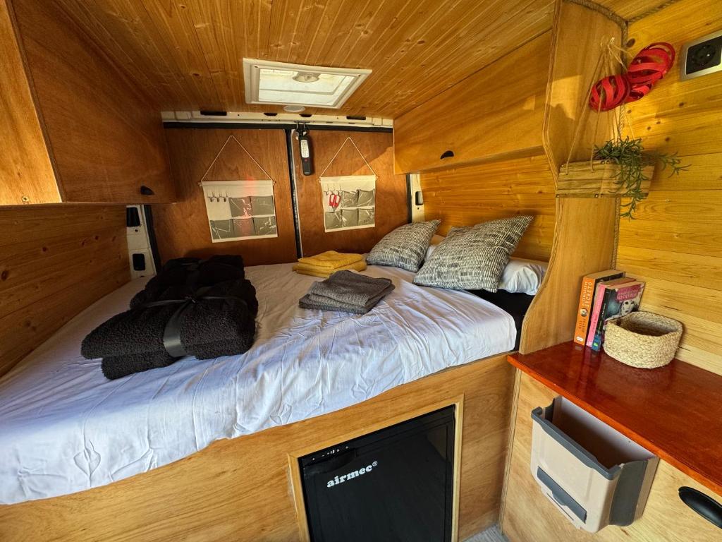 TrapicheFurgoneta camper solo hospedaje sin conducción的一间木屋里有一张床的卧室