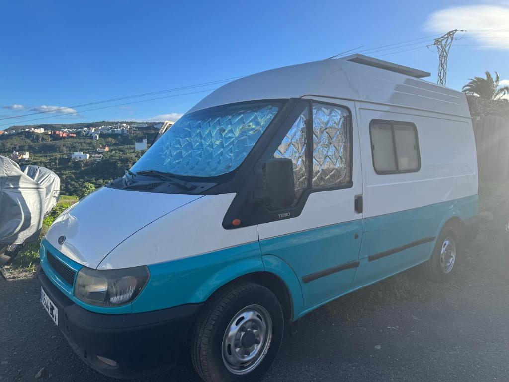 TrapicheFurgoneta camper solo hospedaje sin conducción的停在街上的一辆蓝白货车