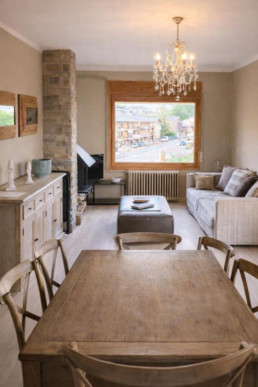 a living room with a table and a couch at CaL QuEROL Llivia 2 piscina, 8 pax, 2 baños y parking in Llivia