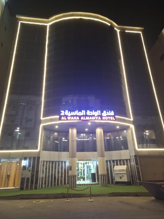 a large building with a sign on it at night at فندق الواحة الماسية 2 in Al Khansāk