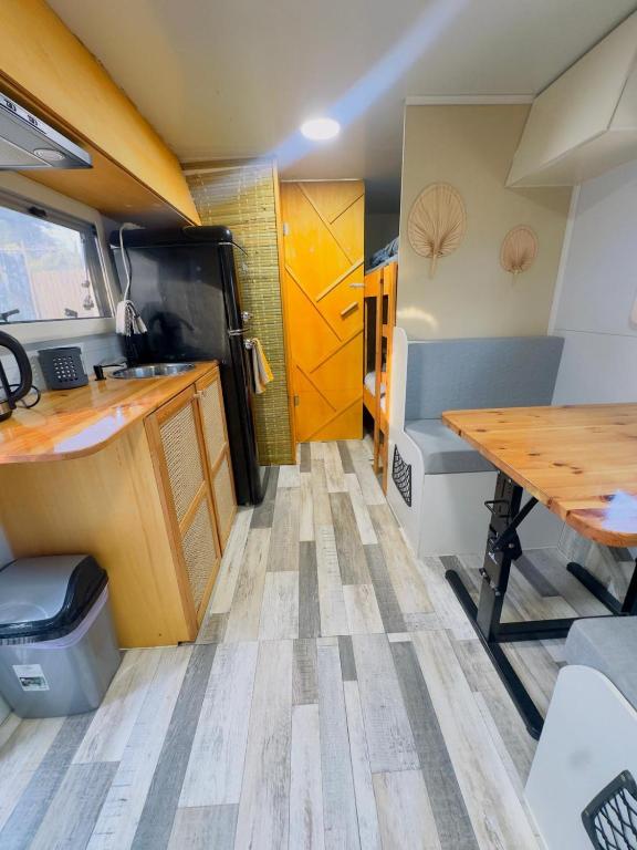 a kitchen and dining area of a trailer with a wooden table at הקרוואן במושב in Beʼerotayim