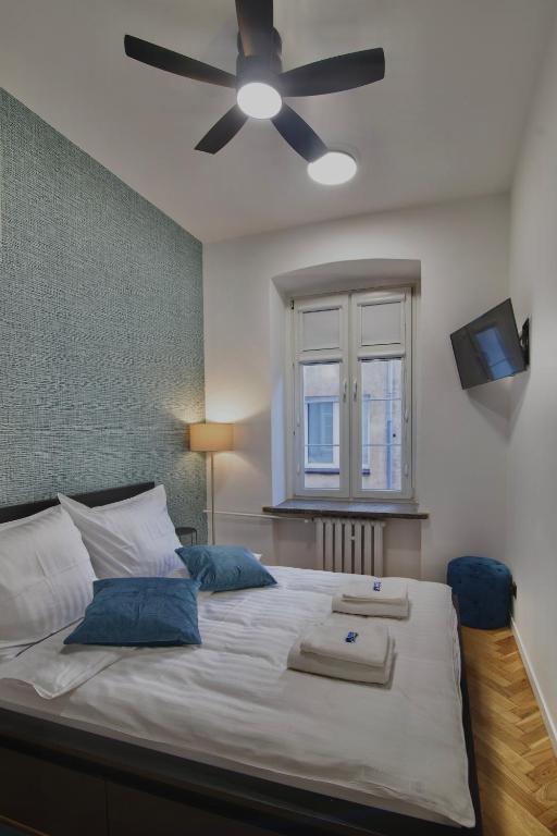 a bedroom with a large bed with a ceiling fan at MonjAna Premium Rynek in Wrocław