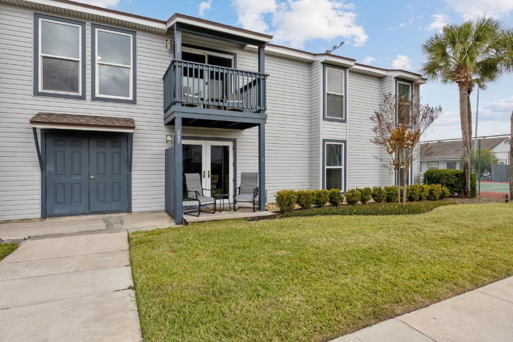a house with a blue door and a balcony at Chill by The Shores - Pet Friendly - Fernandina Beach in Fernandina Beach
