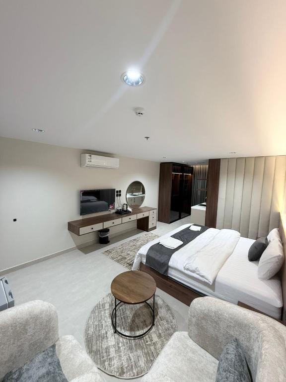 a bedroom with a large bed and two chairs at ديار الاسترخاء للشقق المخدومة اقتصادي in Najran