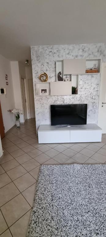 een woonkamer met een bank en een tv bij Appartamento Maria Luminoso e accogliente in Cortona