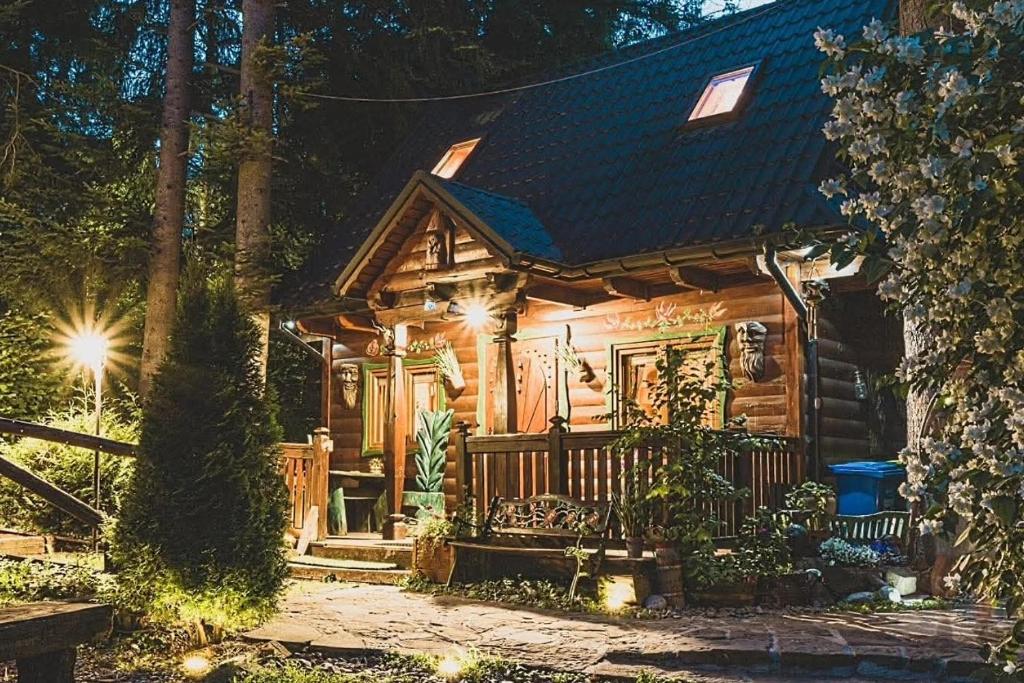 eine Blockhütte mit Veranda bei Nacht in der Unterkunft Baśniowy Domek in Kościelisko