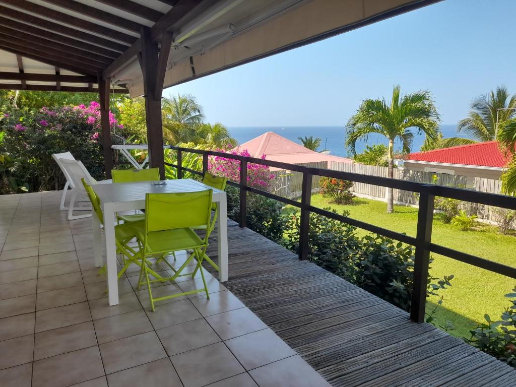 a patio with a table and chairs on a balcony at chez Brigitte et Michel in Les Anses-dʼArlets