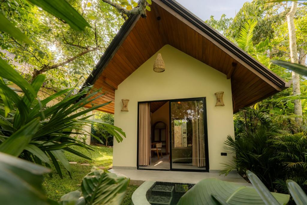 a small house in the jungle with a large glass door at The Benison in Ahangama