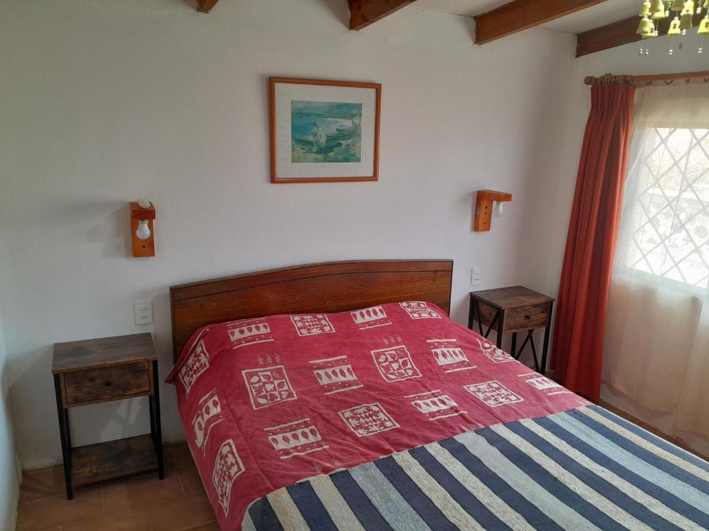 een slaapkamer met een bed met een rode en blauwe deken bij Las Cruces, Sector Playa Chica in San Antonio