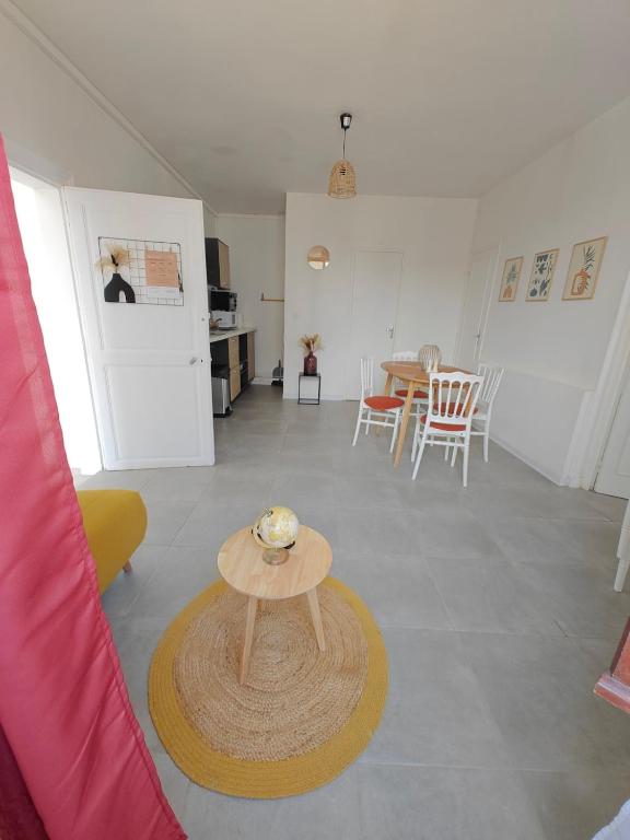 a living room with a table and a dining room at L'Orangerie du Domaine F3 in Forges