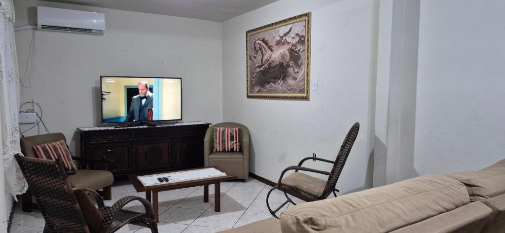 Água BoaCasa Itapema SC的客厅里有一张沙发和一台电视
