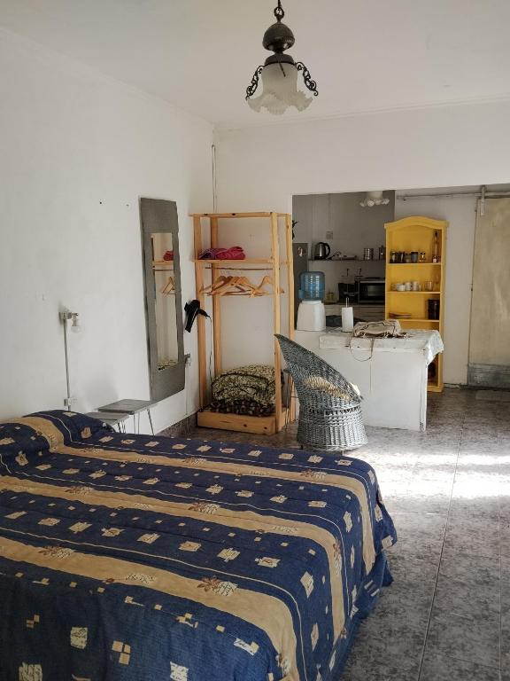 een slaapkamer met een bed en een keuken op de achtergrond bij Monoambiente de Popa in Victoria