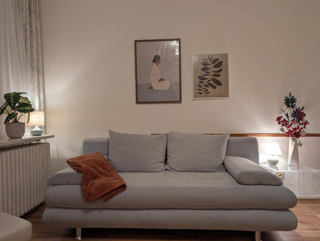 a living room with a gray couch in a room at Modernes Appartement - ruhig, zentrumsnah, abendsonnige Loggia in Bad Füssing