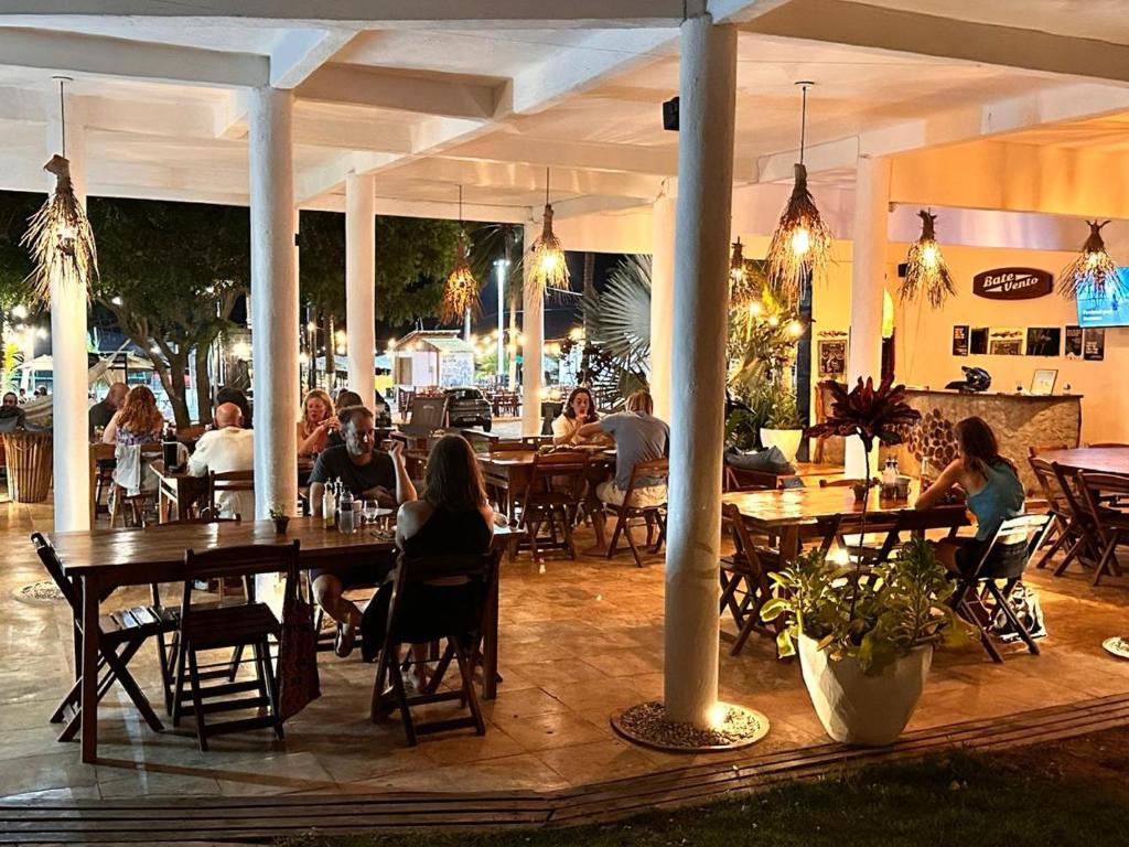eine Gruppe von Menschen, die an Tischen in einem Restaurant sitzen in der Unterkunft Pousada Bate Vento in Itarema