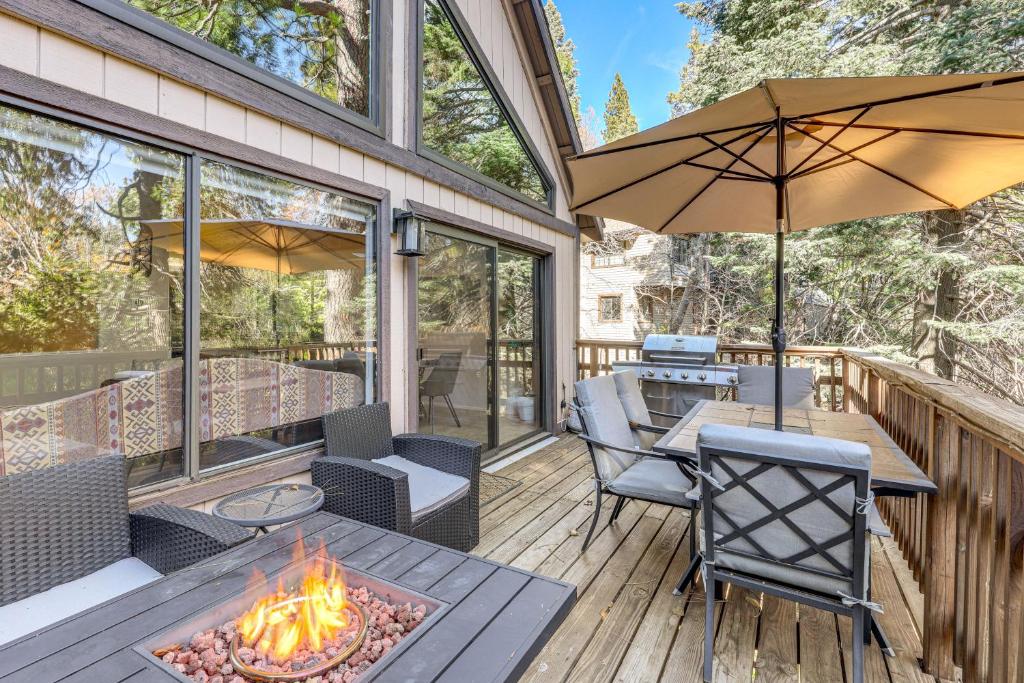 een patio met een tafel en stoelen en een vuurplaats bij 2 Decks! Pet-Friendly Lake Arrowhead Cabin in Skyforest