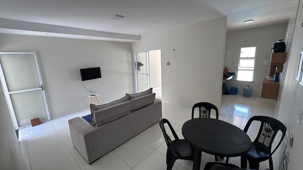 ein Wohnzimmer mit Sofa, Tisch und Stühlen in der Unterkunft Casa com piscina privativa em paracuru in Paracuru