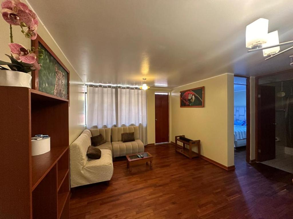 een woonkamer met een bank en een tafel bij Departamento Privado in Lima