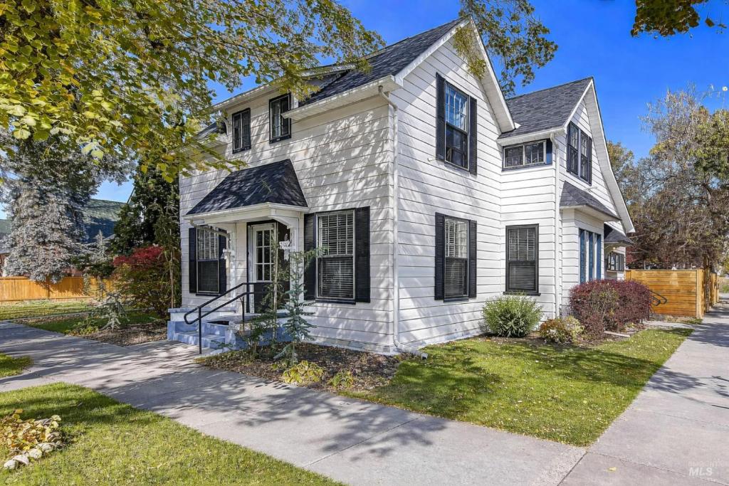 a white house with black windows and a driveway at Assemble Boise in Boise