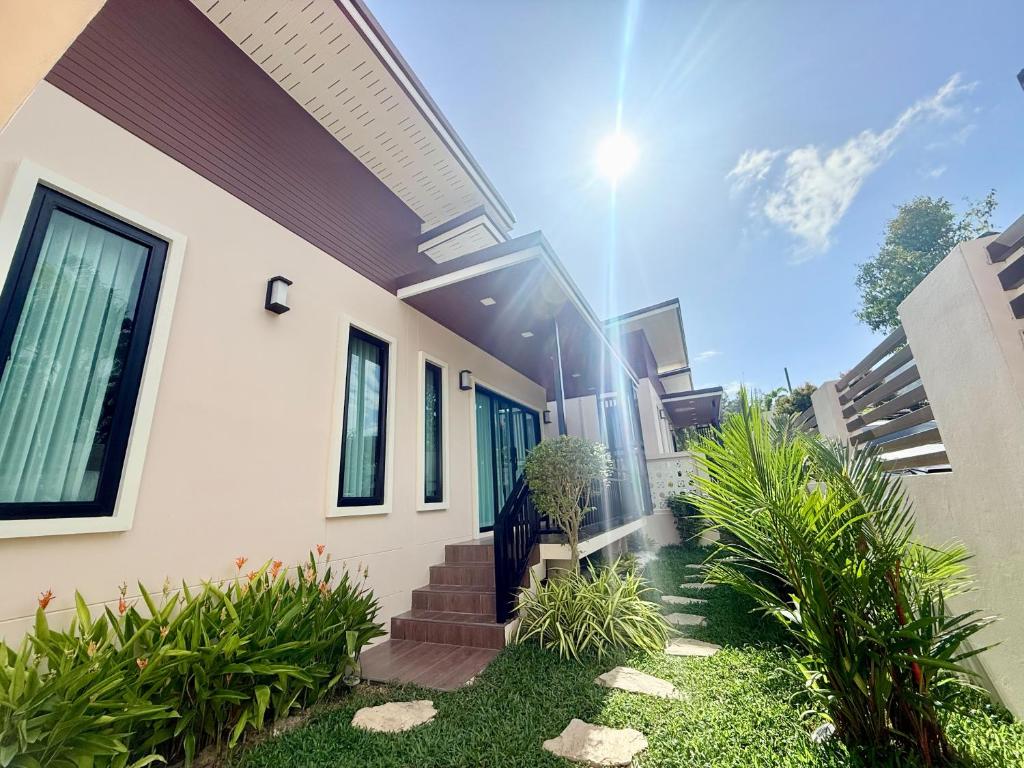 a house with stairs and plants in front of it at PS House Bangtao in Bang Tao Beach