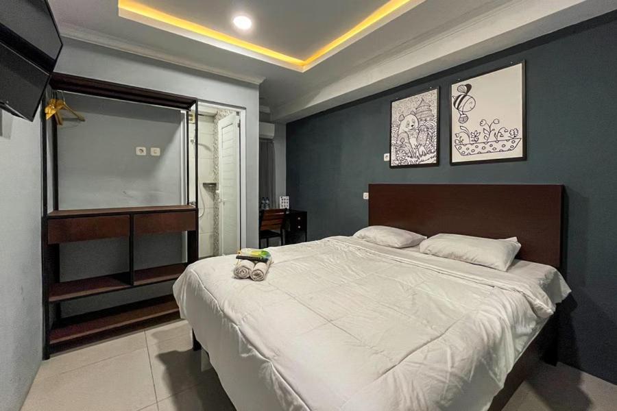 een slaapkamer met een groot bed met een teddybeer erop bij Torisan Hotel in Stasiun Tawang