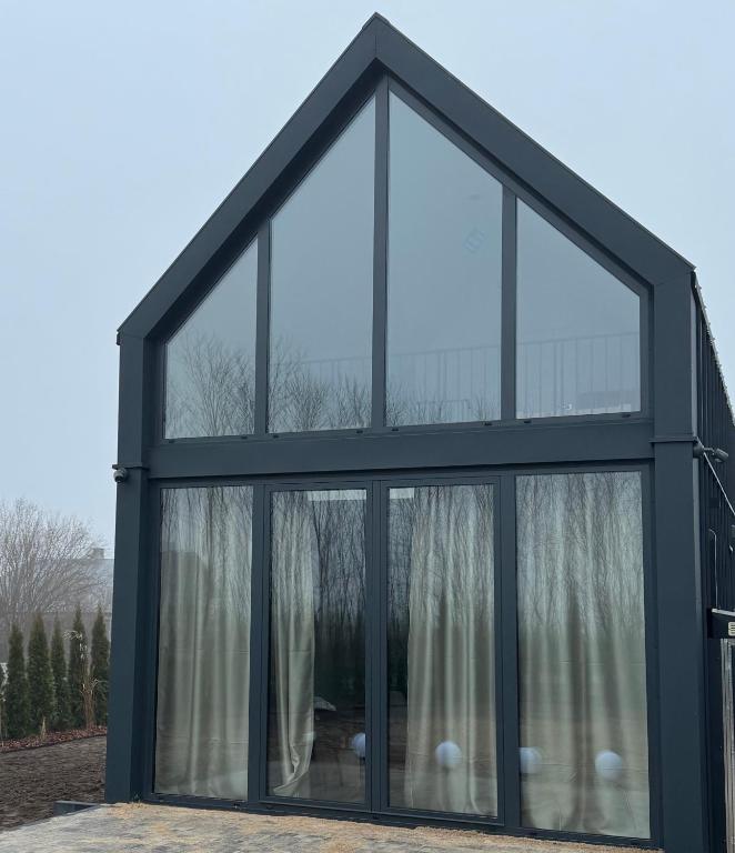 ein großes Fenster in einem Haus mit Vorhängen in der Unterkunft Stodoła Parysa 