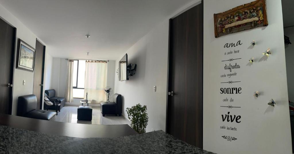 a living room with two chairs and a wall with words at Apartamento Completo Perfecto in Cartago