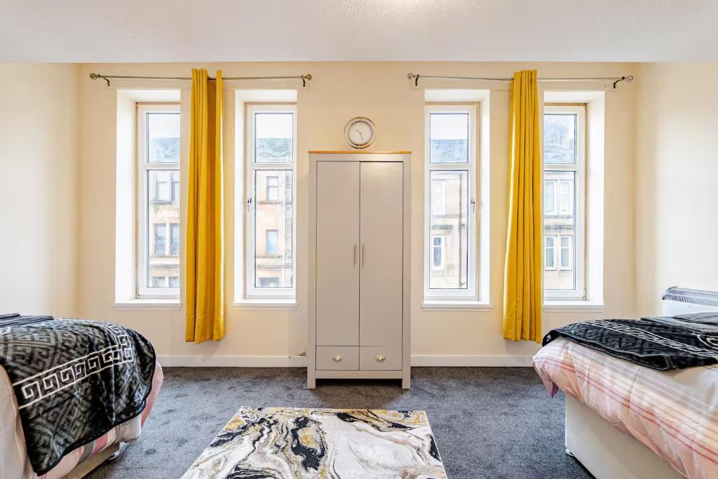 ein Schlafzimmer mit zwei Betten und zwei Fenstern in der Unterkunft Cosy Retreat Suites in Hamilton