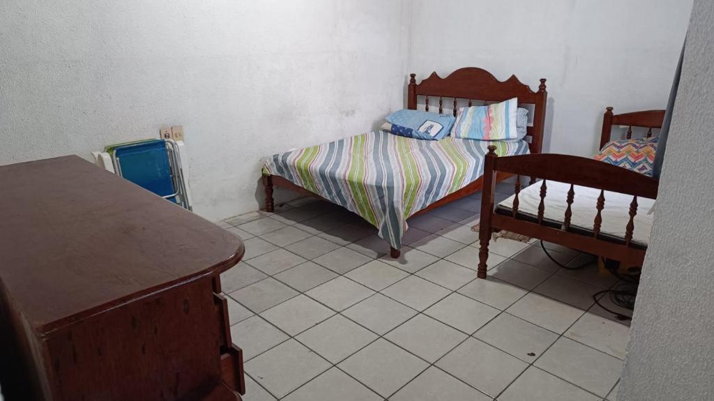 a small bedroom with a bed and a dresser at Praias da Amazônia in Belém