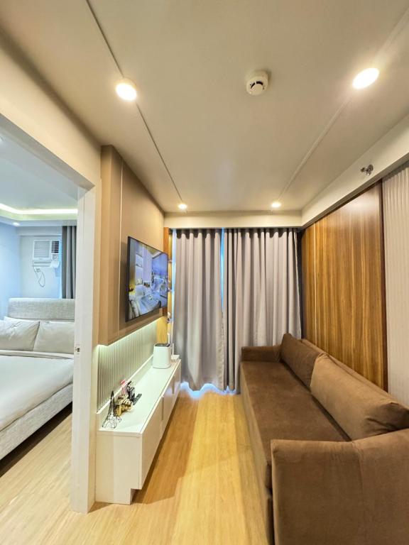 ein Wohnzimmer mit einem Sofa und einem Bett in einem Zimmer in der Unterkunft 1413 Home Suites Arezzo Place Davao in Davao City