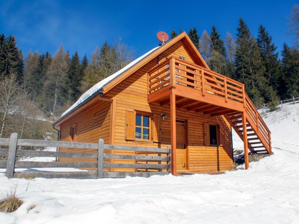 een blokhut in de sneeuw met een hek bij Karawankenpanorama in Liebenfels