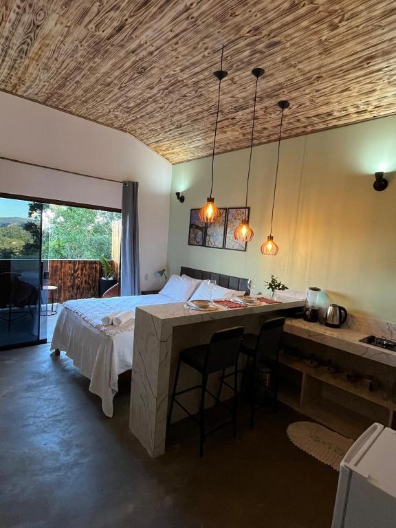 een slaapkamer met een bed en een bureau met een tafel bij Chalé vista da vila in Sao Jorge