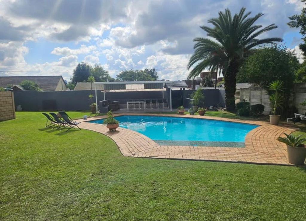 una piscina in un cortile con prato di Peite Grounds Inn a Polokwane