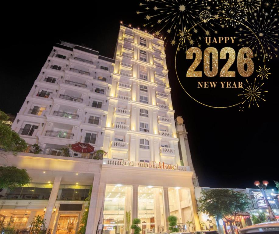 un edificio bianco con un cartello di felice anno nuovo sopra di Galliot Hotel Nha Trang a Nha Trang