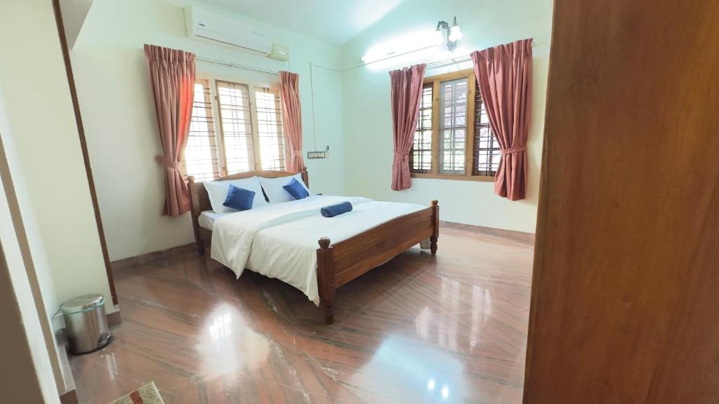 una camera da letto con un letto e due finestre di Indeevaram a Cochin