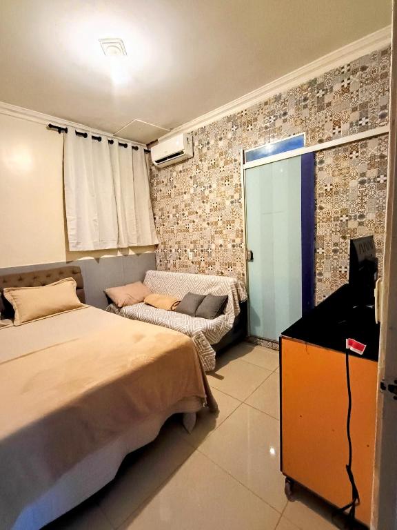 a bedroom with a bed and a television in it at Apto inteiro 3 quartos, sendo duas suítes in Belém