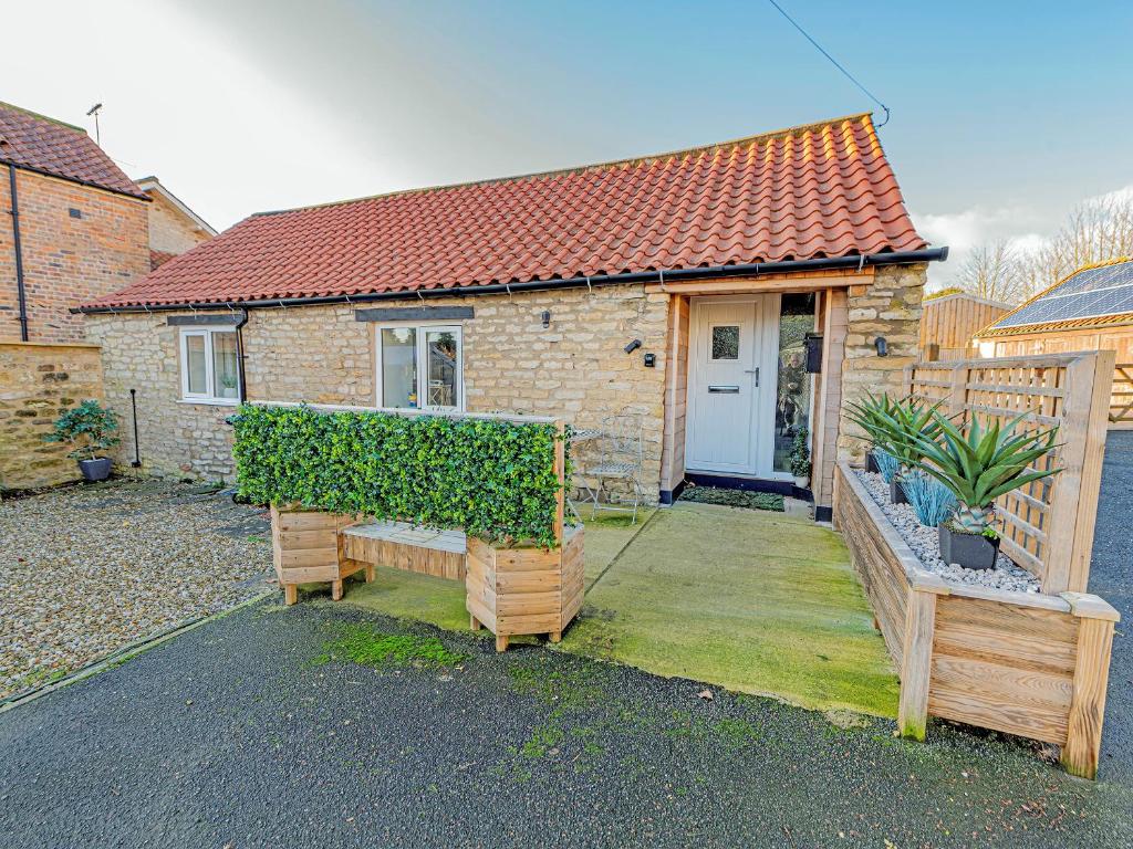 een stenen huis met een bank ervoor bij The Granary - Uk45696 in Pickering