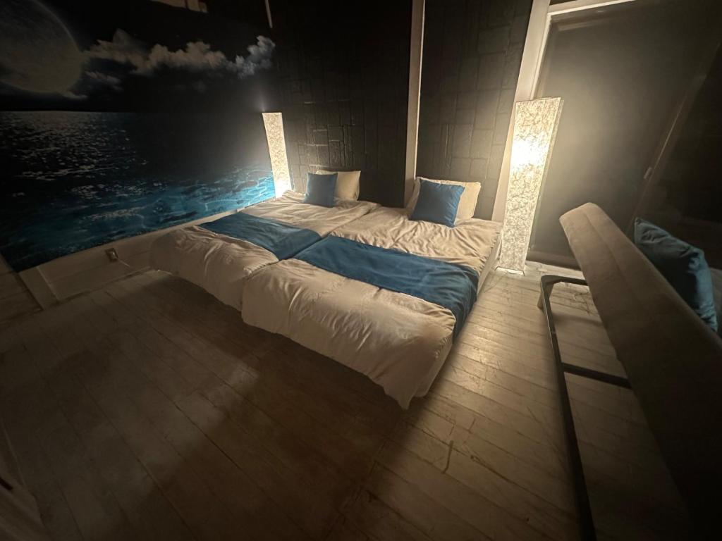 ein Schlafzimmer mit einem großen Bett mit Licht in der Unterkunft Tiny Camp House Kurage - Vacation STAY 66334v in Kamijinoo