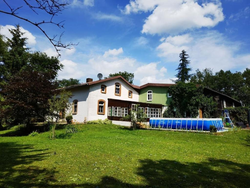 een huis met een grote tuin met een groen veld bij Farmhouse for arrival in Lütjenwestedt